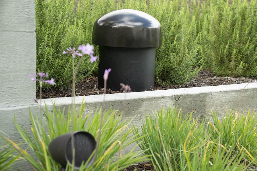 Small and large Sonance speakers in the garden area of a home.
