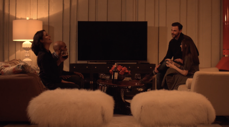 two couples sitting in a living room having a conversation 