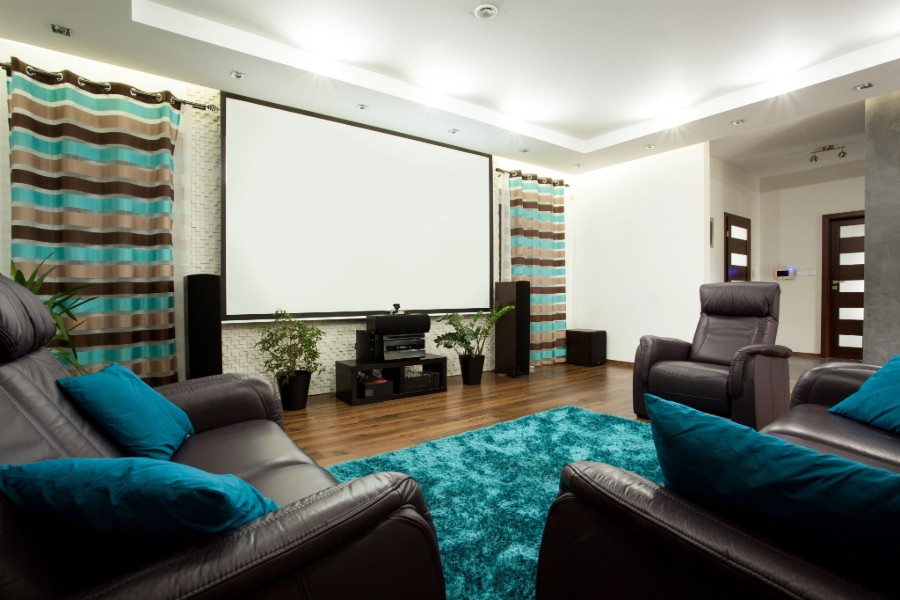  A home theater room with leather chairs and a projector screen.