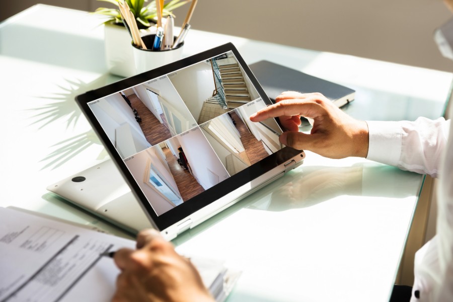 Person reviewing security camera footage on a tablet at a desk.