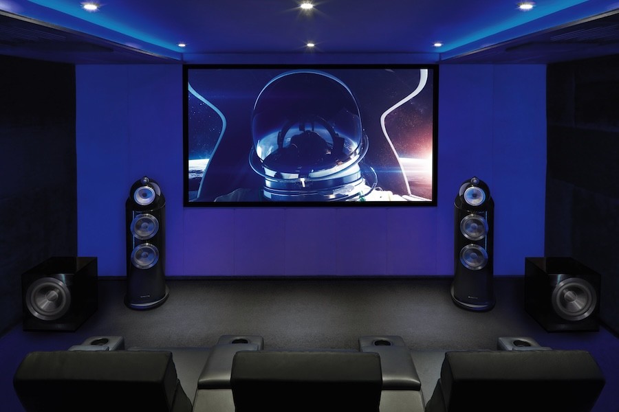 Bowers & Wilkins speakers flank a large screen in a home theater room.