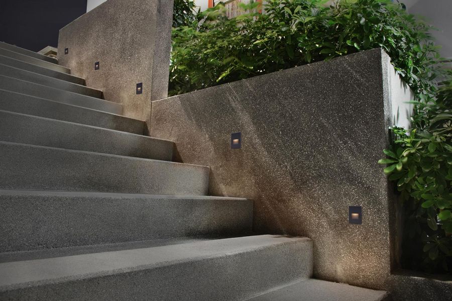 Softly lit modern stone steps using built-in vertical wall fixtures